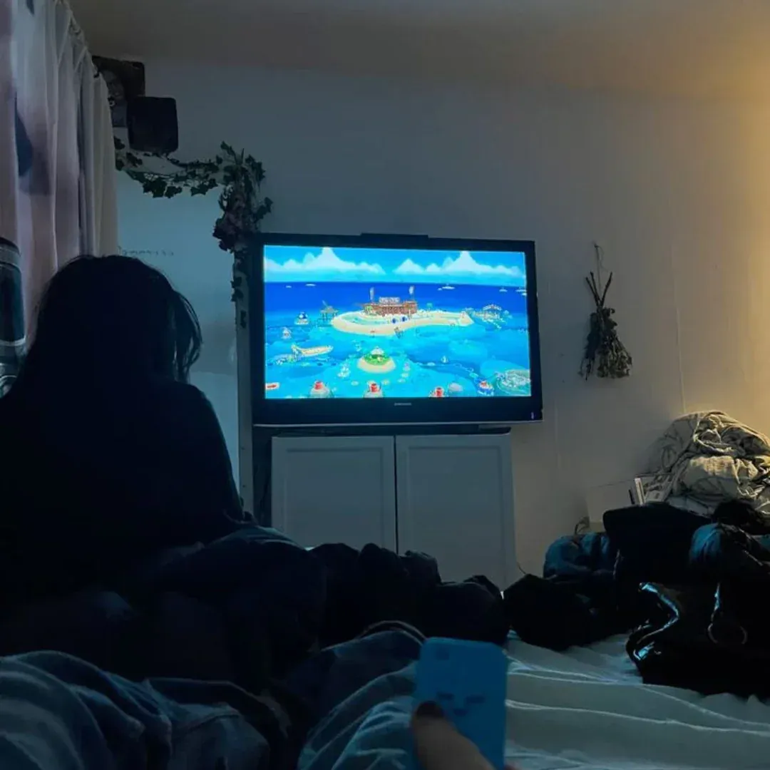 Person cozy in bed watching TV at night